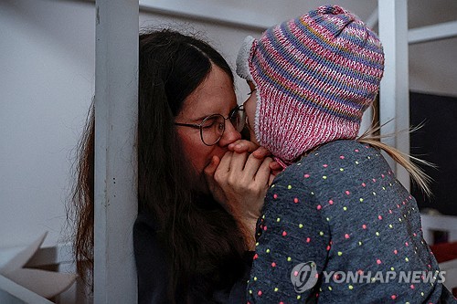 세살짜리 아이 손 녹여주는 키이우 시민